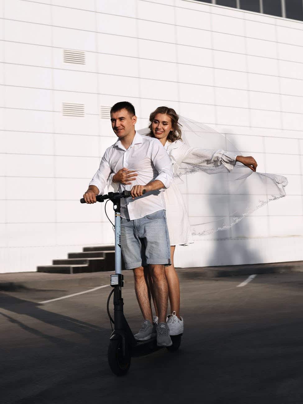 man and woman riding an electric scooter