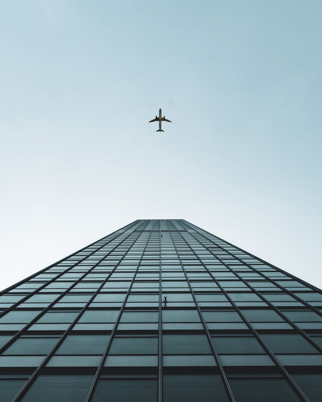 an airplane flying over the tall building