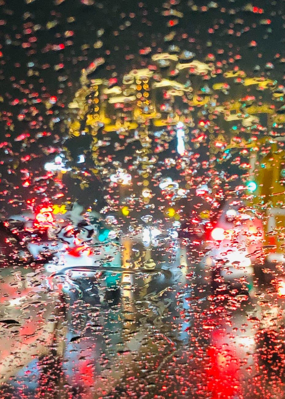 colorful city lights seen through window during rain