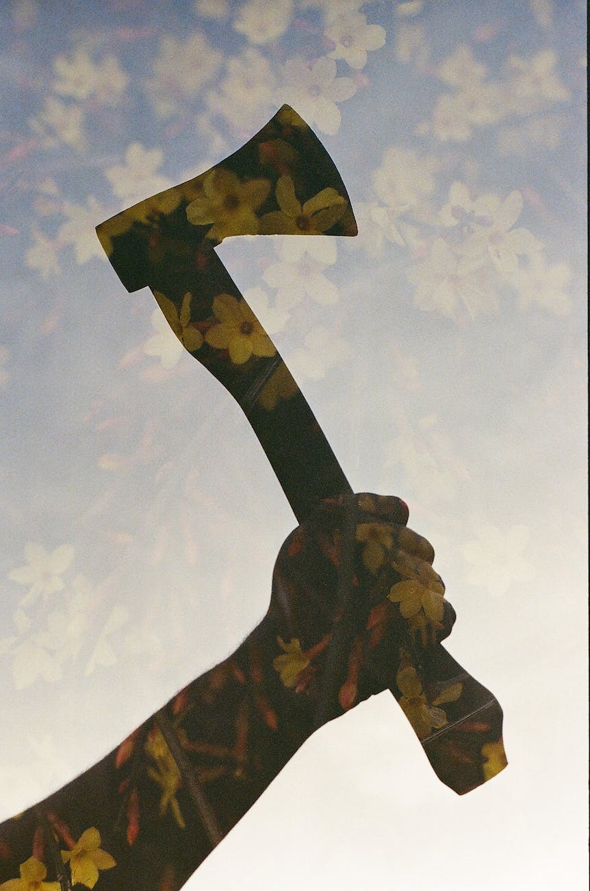 double exposure of man holding axe and yellow flowers