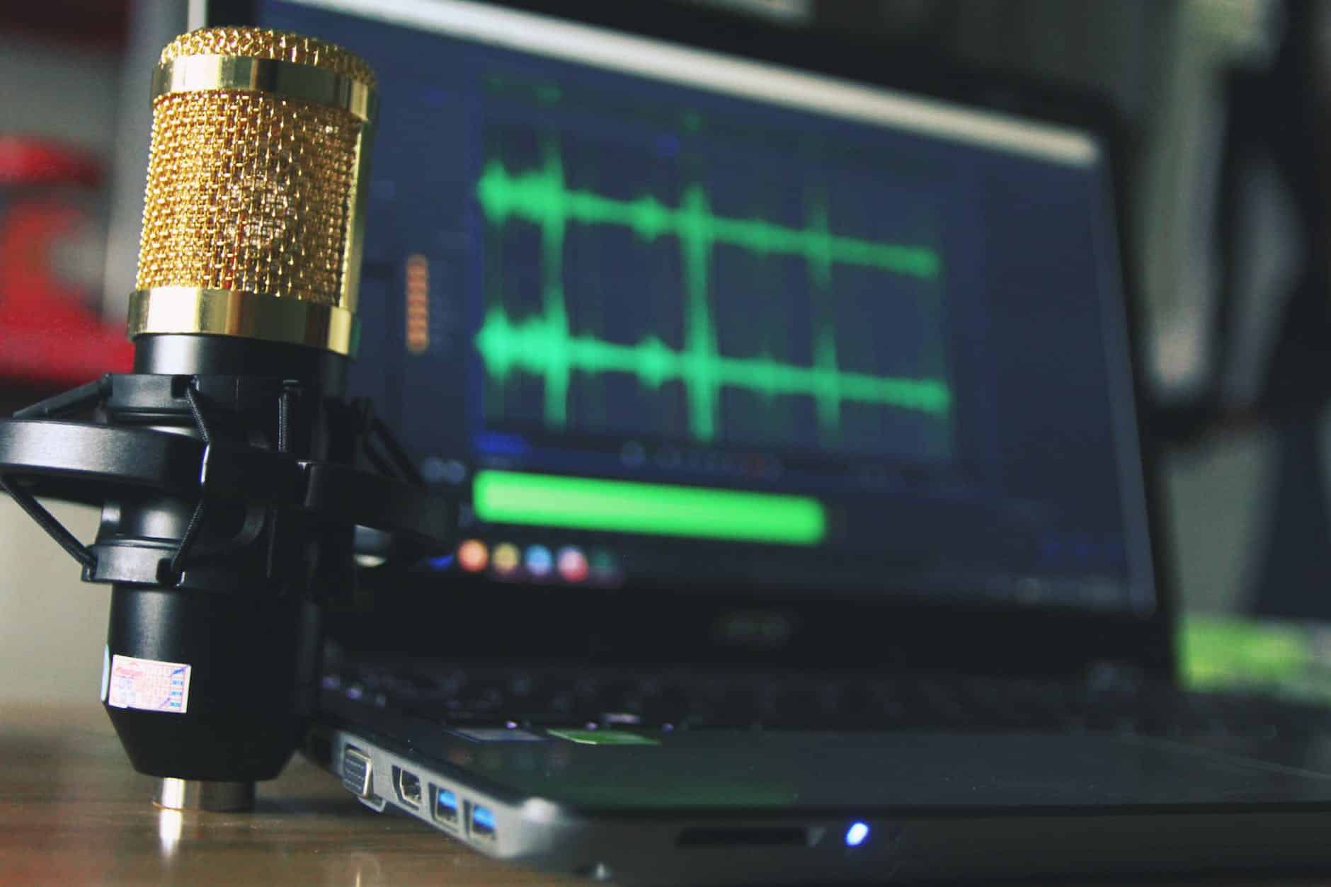 gold condenser microphone near laptop computer