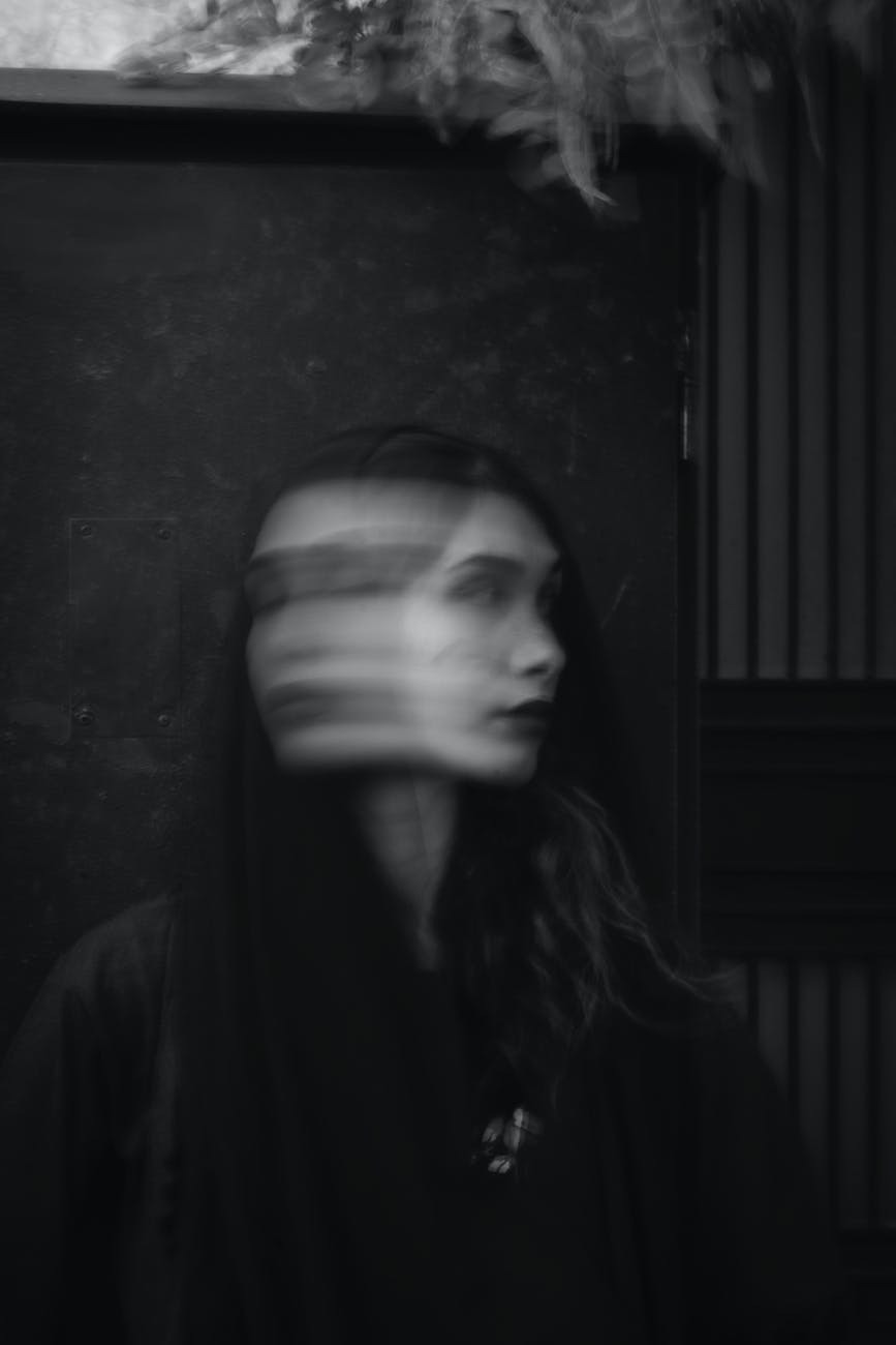 woman in black top standing beside wall